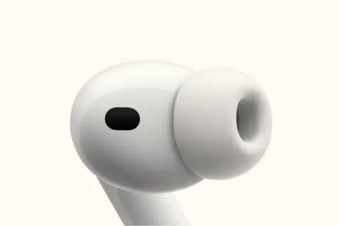 Close-up of a white Apple AirPod with a black sensor.