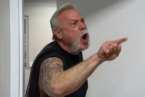 Two men in a heated argument in an office setting.