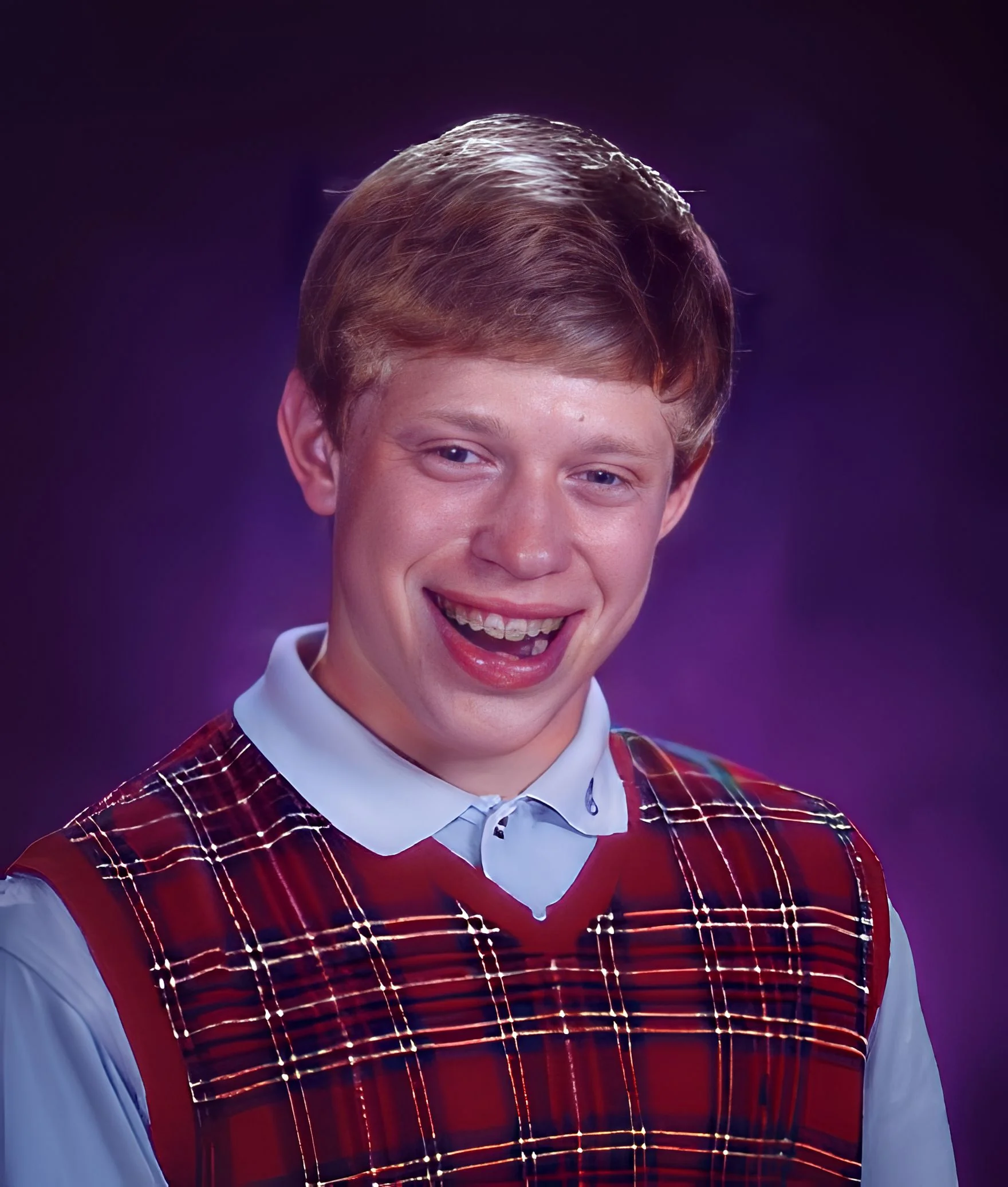 Teenager with braces and plaid vest smiling awkwardly against a purple background.