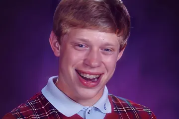 Teenager with braces and plaid vest smiling awkwardly against a purple background.