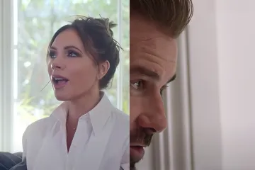 Victoria Beckham sitting on a couch with David Beckham peeking from behind a wall.