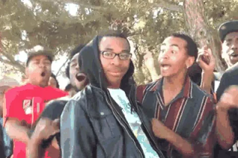 Group of young men reacting with excitement and surprise outdoors.