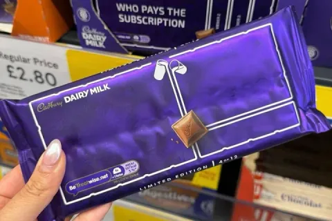 Person holding a Cadbury Dairy Milk chocolate bar with unique packaging design.