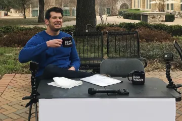 Man sitting at a table with a sign that reads 'Change My Mind'.