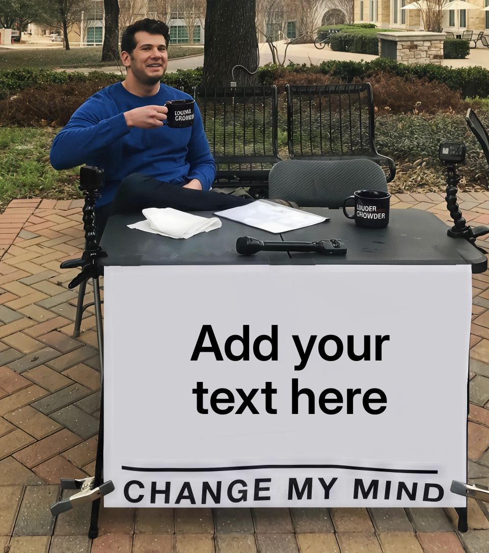 Man sitting at a table with a sign that reads 'Change My Mind'.