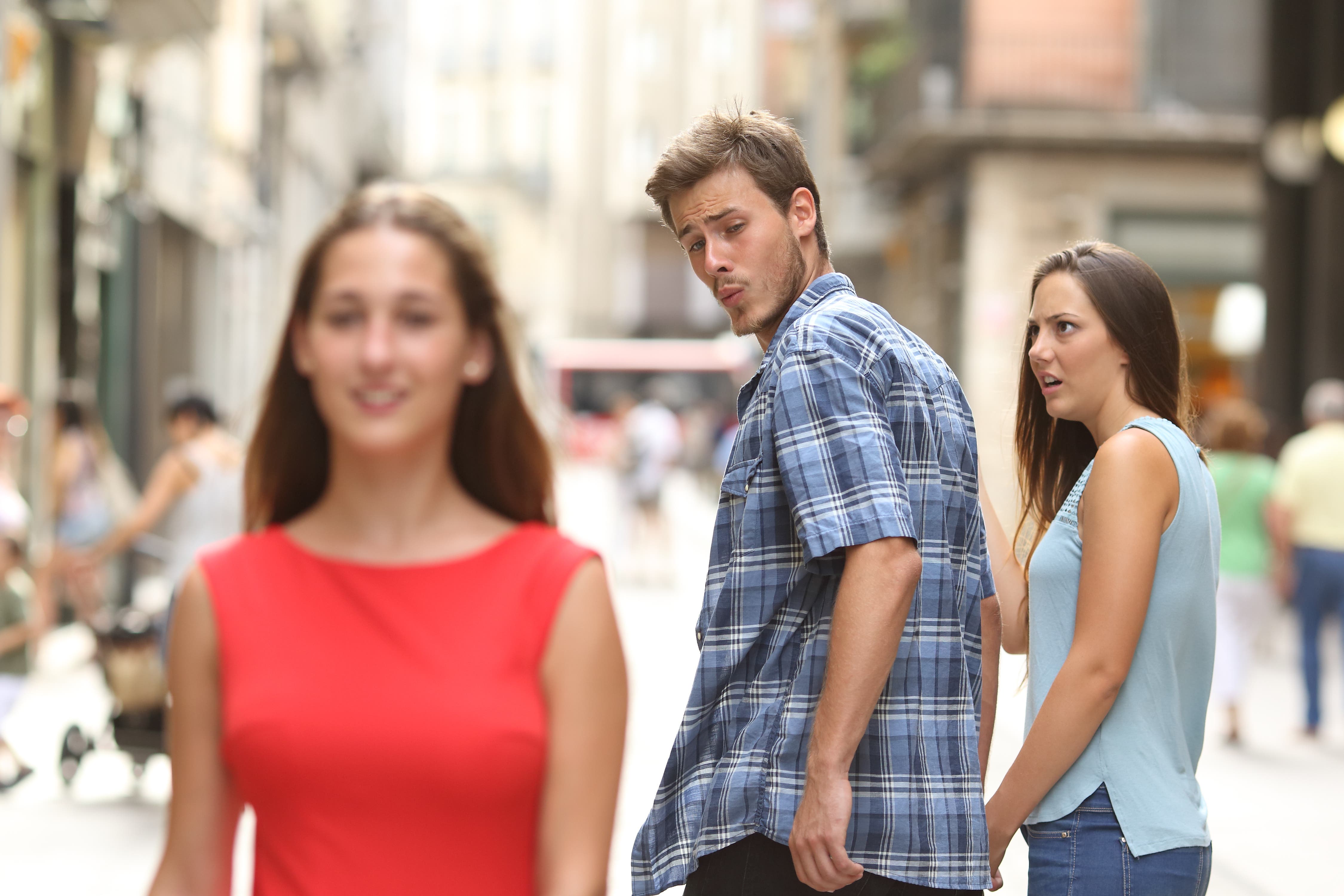 Man looking at another woman while his girlfriend looks shocked.
