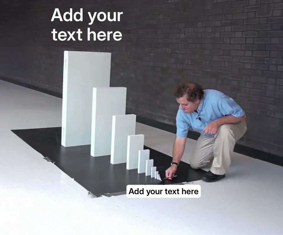 A man setting up a series of increasingly larger dominoes on a black surface.