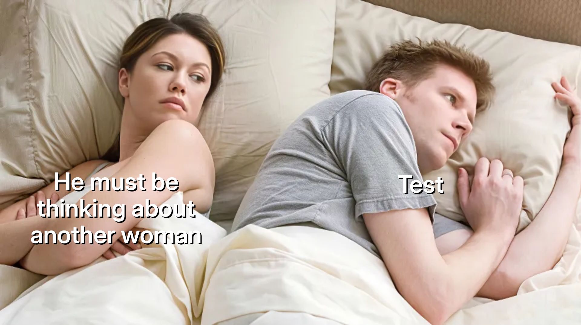 A woman and man lying in bed, woman looking suspiciously at the man.