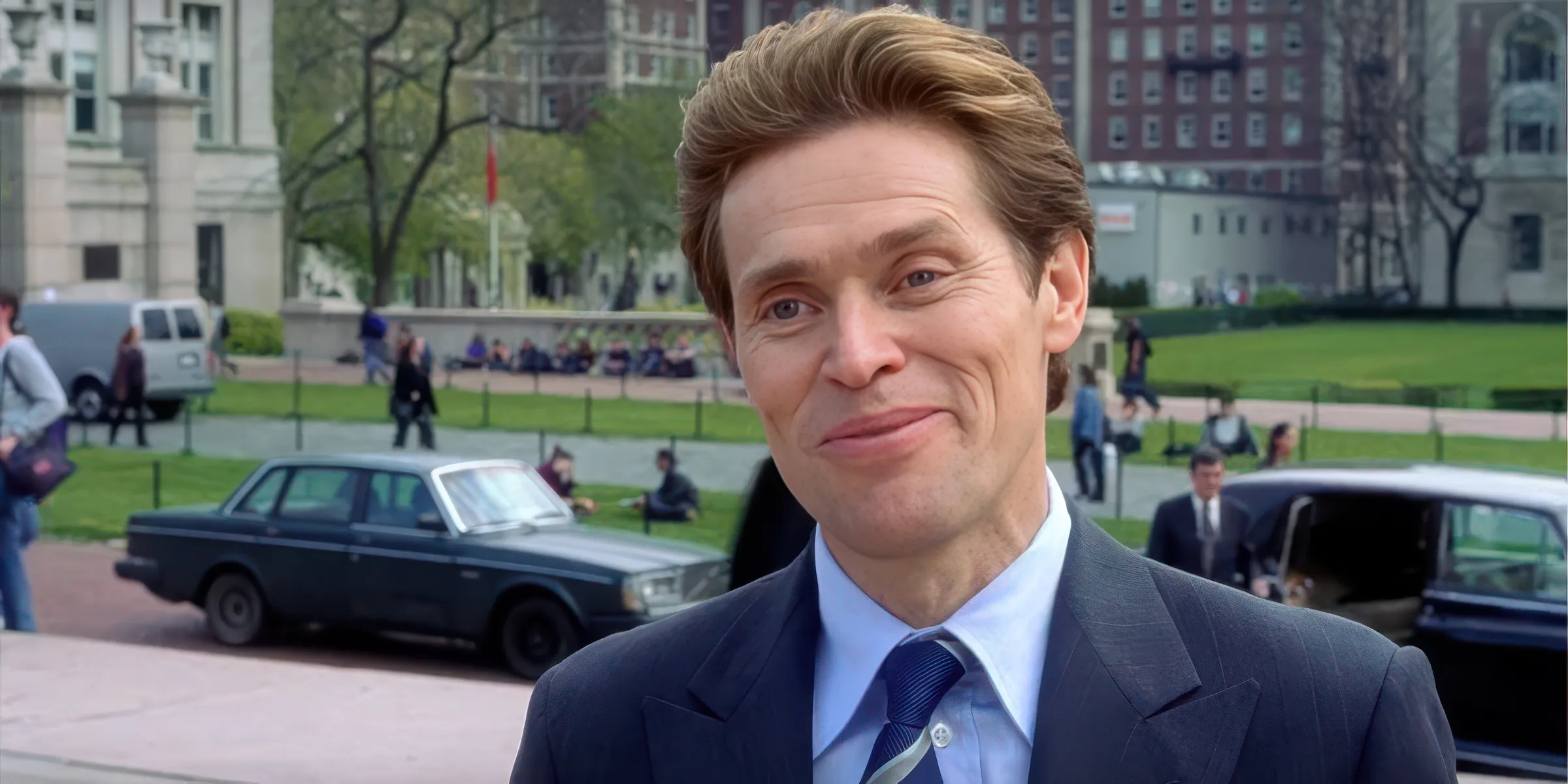 A man in a suit smirking outdoors, from a movie scene.