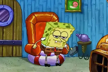 SpongeBob SquarePants sitting in a chair looking tired and holding a remote control.