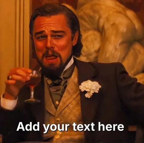 Leonardo DiCaprio in a suit holding a drink, laughing with a scrunched face.
