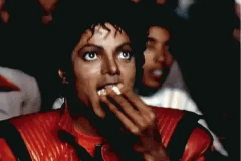 Michael Jackson eating popcorn in a movie theater scene from the Thriller music video.
