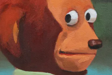 A painted monkey puppet with wide eyes looking sideways, wearing a green shirt.