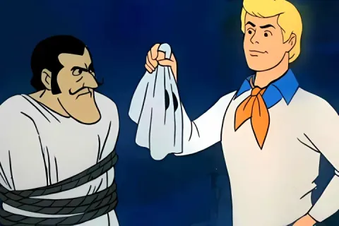 Fred revealing a masked villain in Scooby-Doo cartoon.