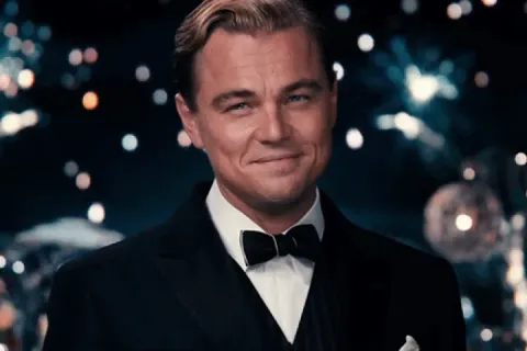 Leonardo DiCaprio as Jay Gatsby raising a glass in a celebratory toast.