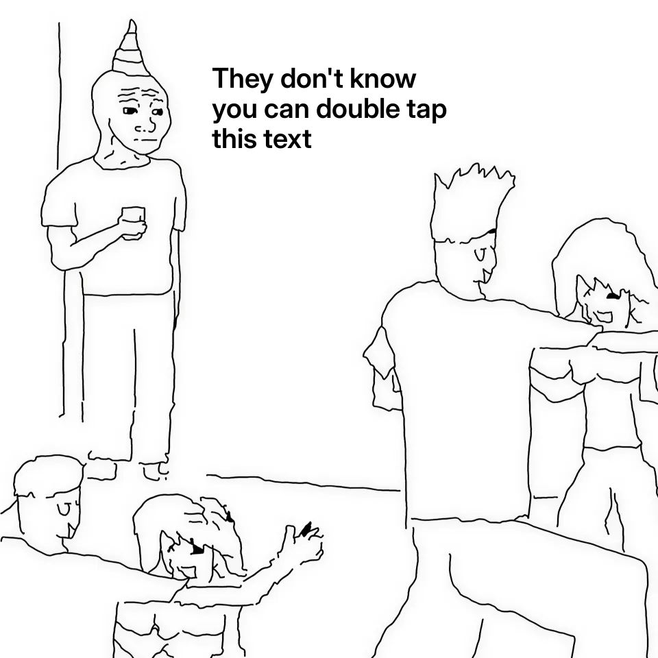 A person with a party hat standing alone at a party, holding a drink, while others dance.