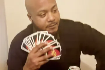 A person holding UNO cards, facing a choice between playing a card or drawing 25 cards.