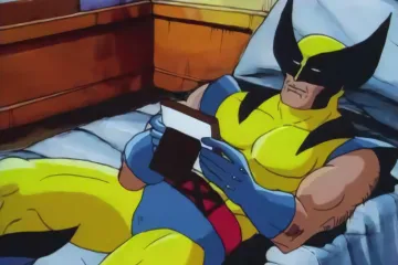 Wolverine lying on a bed holding a picture frame with a blank space.