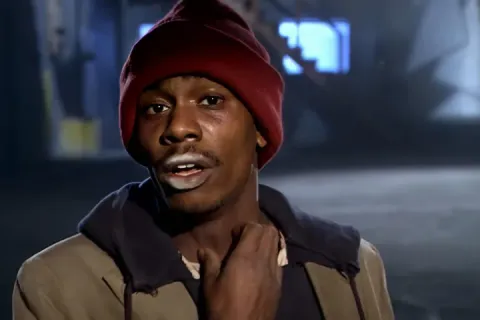 A man in a red beanie and brown jacket looking desperate.